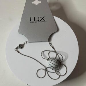 Lux metal ball charm on silver necklace